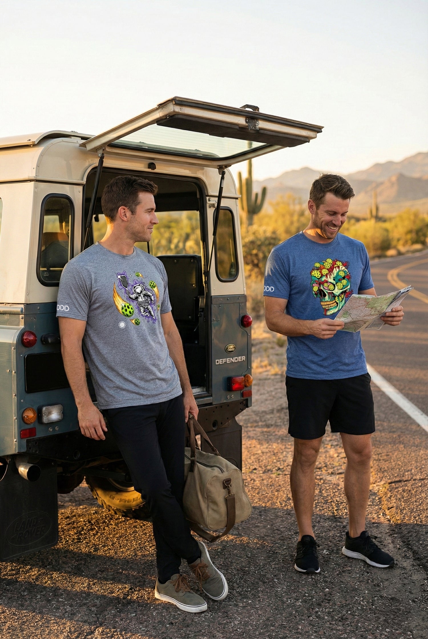 Two men standing next to an open van in a desert setting, one holding a map.